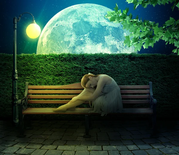 Girl sitting on bench on big moon background — Stock Photo, Image