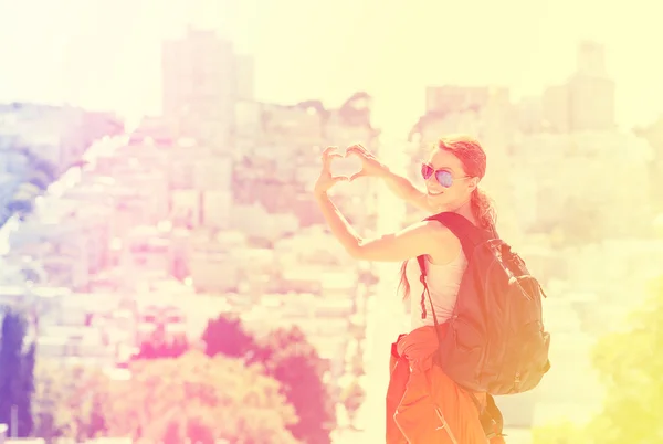 Giovane donna nella città di San Francisco con un sorriso raggiante retroilluminato dal caldo bagliore del sole — Foto Stock