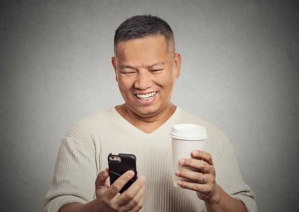 Šťastný člověk při pohledu na mobilní telefon drží šálek kávy — Stock fotografie