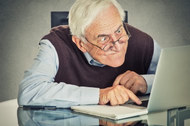 Yaşlı ihtiyar masada oturan dizüstü bilgisayar kullanan