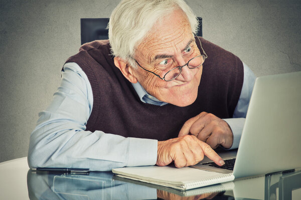 Старик, сидящий за столом с ноутбуком
