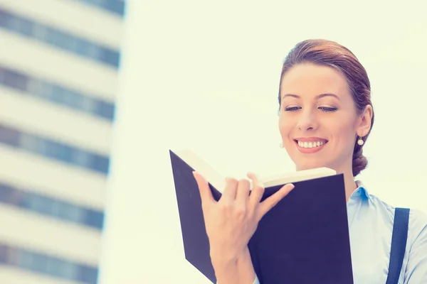 Bella giovane donna in piedi leggendo un libro all'aperto — Foto Stock