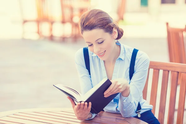 Vacker ung kvinna läser bok utomhus. — Stockfoto