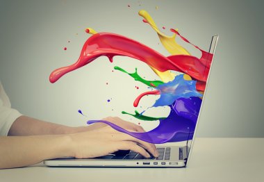  Hands on keyboard with colorful splashes out of monitor