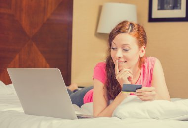 kadın yatakta kredi kartı alışveriş online tutarak laptop ile döşeme