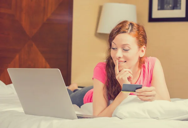 Γυναίκα, βάζοντας στο κρεβάτι με το lap-top κρατώντας πιστωτική κάρτα αγορών σε απευθείας σύνδεση — Φωτογραφία Αρχείου