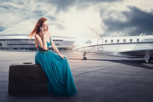 Mujer esperando la salida del vuelo en el aeropuerto hablando por teléfono — Foto de Stock