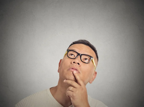 Uomo con gli occhiali pensando alzando lo sguardo — Foto Stock