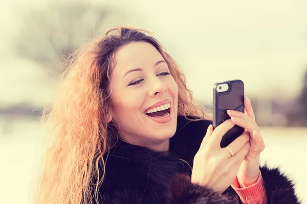 Glad, glad kvinna upphetsad av vad hon ser på mobiltelefon — Stockfoto