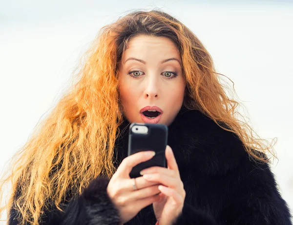 Chockad kvinna som tittar på mobiltelefon ser dåliga nyheter — Stockfoto
