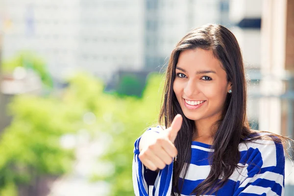 Woman with thumbs up isolated on city background — Stock Photo, Image