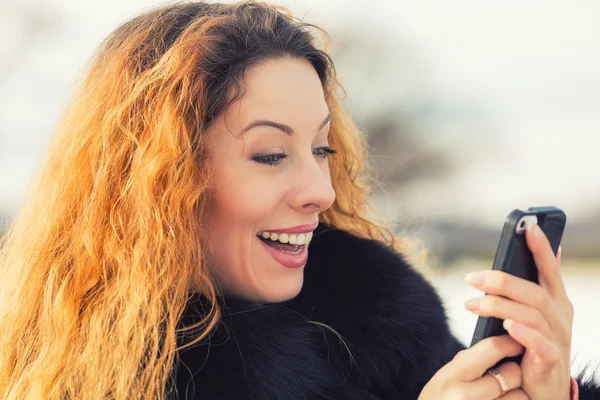 Vacker kvinna skickar SMS från sin mobiltelefon — Stockfoto