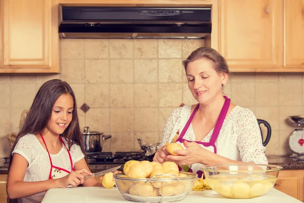 Lycklig, leende mor och dotter matlagning middag — Stockfoto