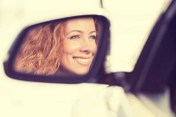 Mulher feliz motorista reflexão no carro espelho vista lateral — Fotografia de Stock