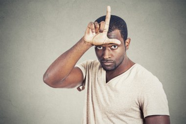 man showing loser sign on forehead looking at you clipart