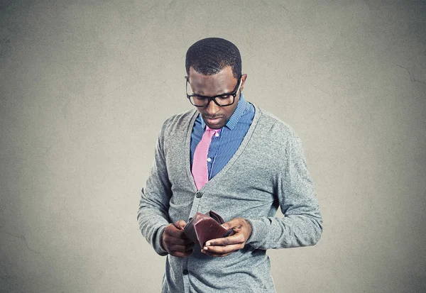 Young man looking into his empty wallet has no money — Stock Photo, Image