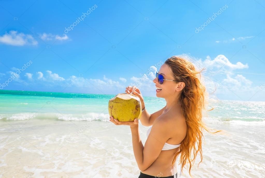 Woman with sunglasses on tropical beach enjoying ocean view