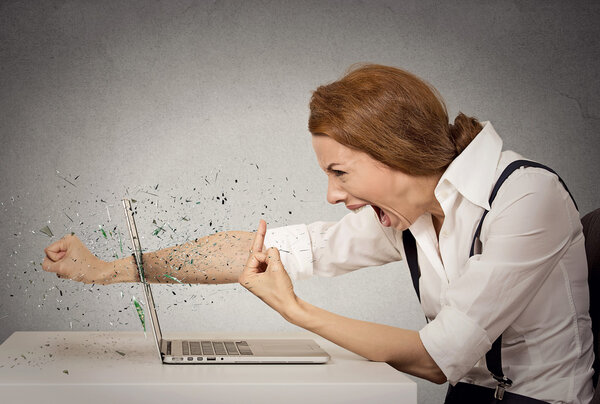 сердитая деловая женщина бросает удар в компьютер, крича:
