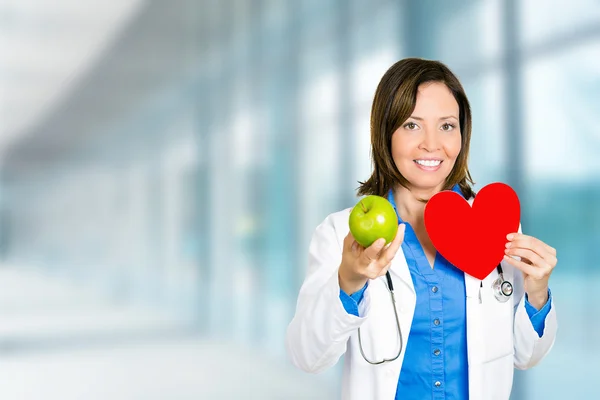 Profesional de la salud médico femenino con manzana verde corazón rojo — Foto de Stock