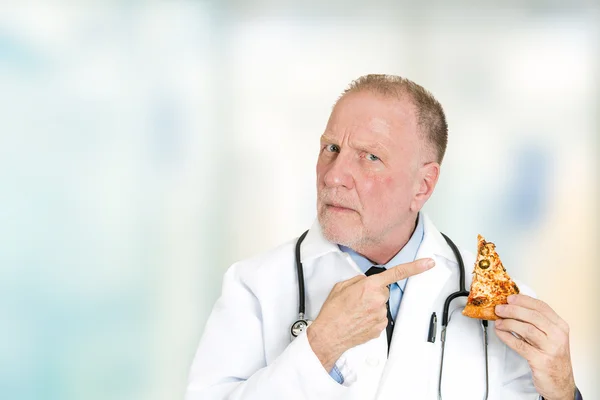 Arzt rät von fetthaltigem Essen ab, das auf ein Stück Pizza zeigt — Stockfoto