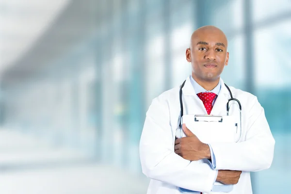 Szczęśliwy pewnie młody lekarz stojący w korytarzu szpitala — Zdjęcie stockowe