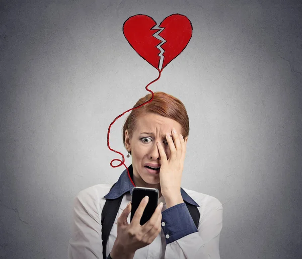 Sad woman with broken heart looking at her mobile phone — Stock Photo, Image