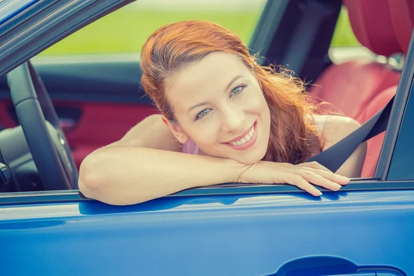 Mujer feliz sonriente sentada en un coche azul nuevo —  Fotos de Stock