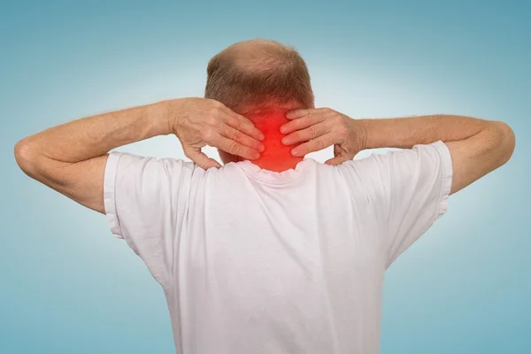 Старик со спазмом шеи трогает красную воспаленную область — стоковое фото