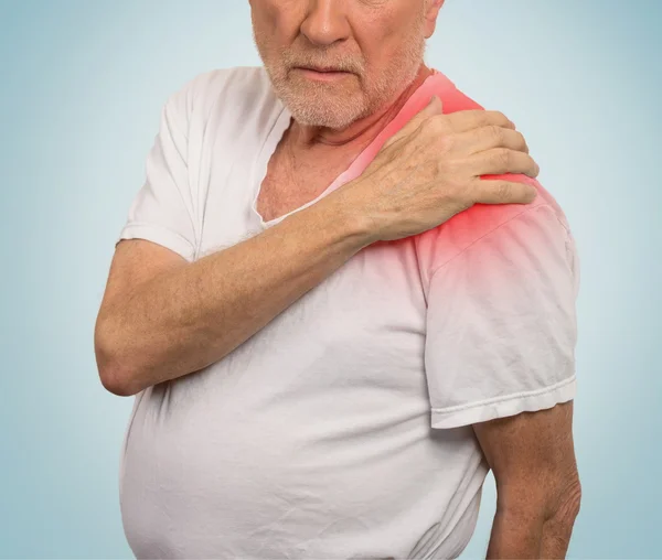 Senior Mann mit Schmerzen in der Schulter isoliert blauen Hintergrund — Stockfoto