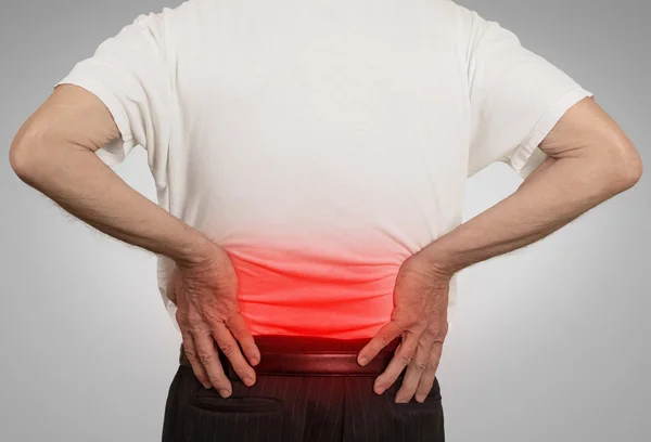 Old man grandpa holding his painful lower back colored in red — Stock Photo, Image