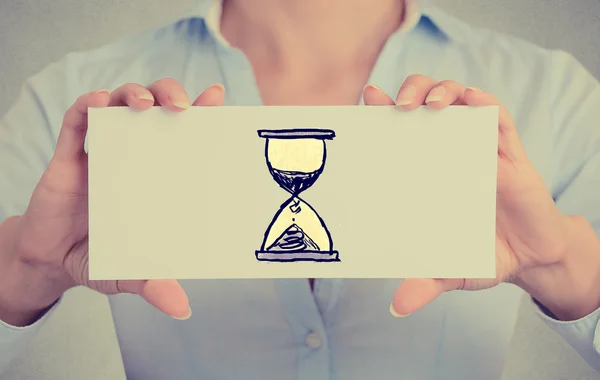 Time management concept. Woman hands card with sand clock sign — Stock Photo, Image