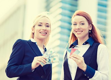 kredi kartları ve nakit ödül tutan mutlu iş kadınları