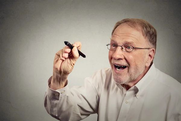 Senior opgewonden mens iets schrijven met pen op blackboard — Stockfoto