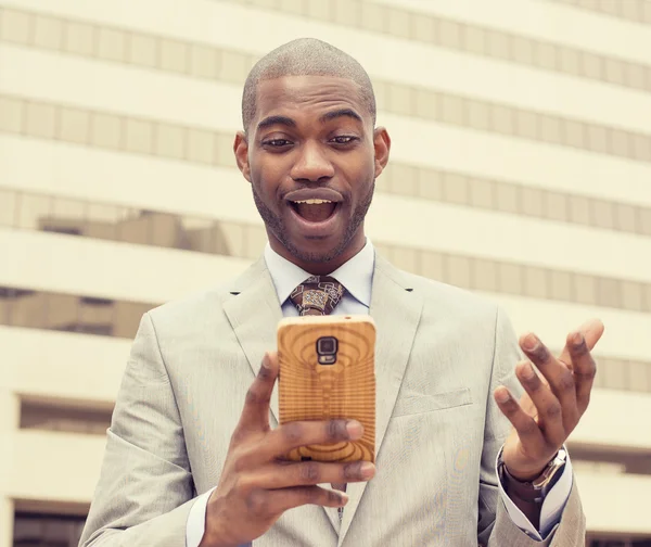 Překvapen, pohledný mladý muž při pohledu na telefon — Stock fotografie