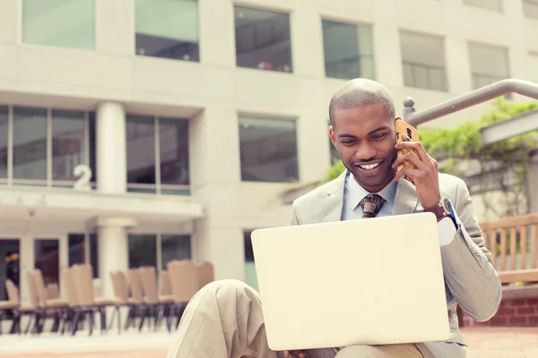 Empresário trabalhando com laptop ao ar livre falando no telefone móvel — Fotografia de Stock