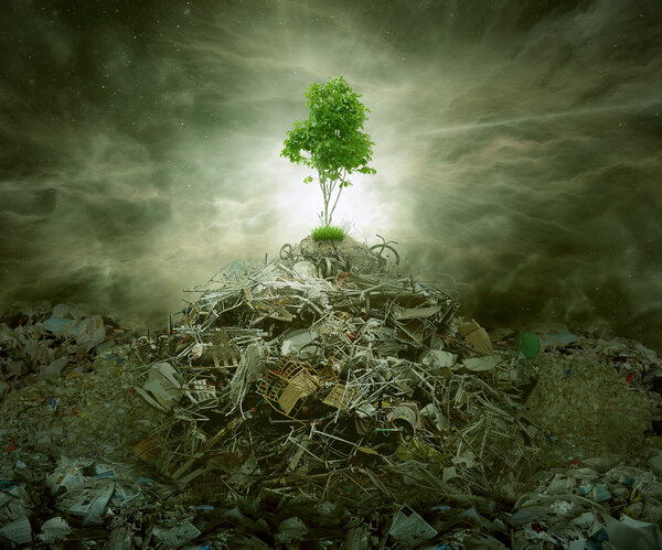Green concept as tree on top mountain heap of garbage 