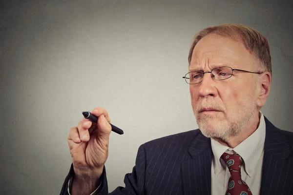 Primer plano retrato hombre de negocios escribiendo en una pared gris — Foto de Stock