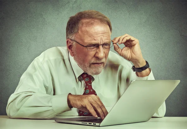 Oudere man met bril verward met laptop software — Stockfoto