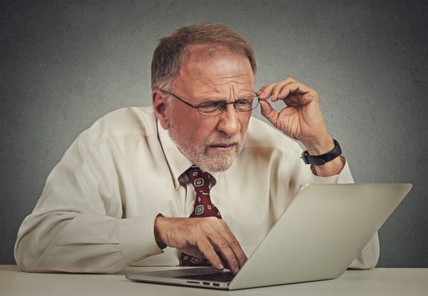 пожилой человек в очках путают с ноутбуком программного обеспечения
 