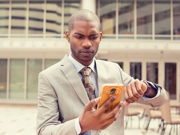 Hombre de negocios mirando el reloj de teléfono móvil se queda sin tiempo — Foto de Stock