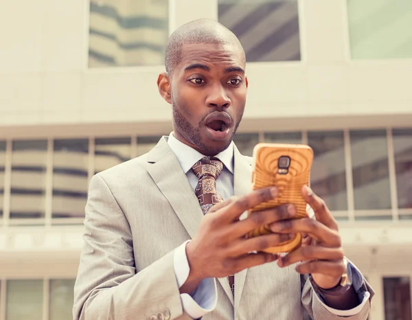 Anxious young business man looking at phone seeing bad news — Stock Photo, Image