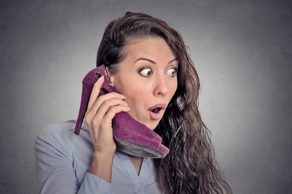 Mulher surpreso segurando sapato de salto alto na mão como telefone — Fotografia de Stock