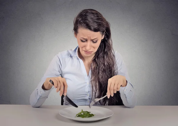 Femme fatiguée des restrictions alimentaires manger de la salade verte — Photo