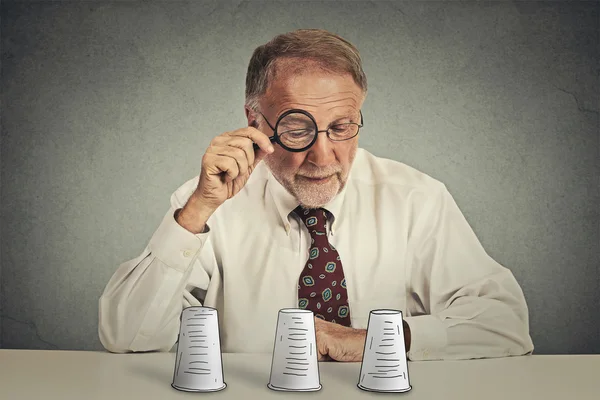 Man looking through magnifying glass playing conjuring trick game — Stock Photo, Image