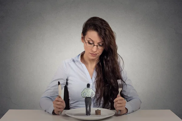 Woman sitting in front of a dish looking at a tiny man Royalty Free Stock Images