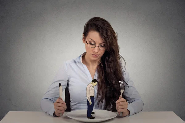 Woman sitting in front of a dish looking at a tiny man Stock Photo