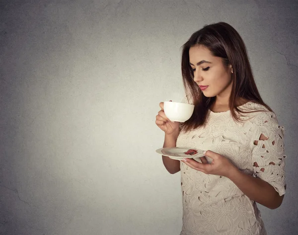 Jovem mulher bebendo café isolado no fundo da parede cinza — Fotografia de Stock