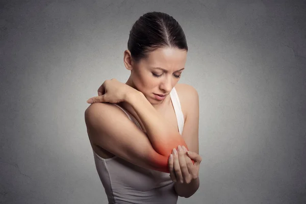 Woman with painful elbow on gray background — Stock Photo, Image