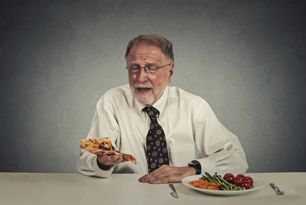 Triste homme regardant pizza fatigué du régime de salade — Photo