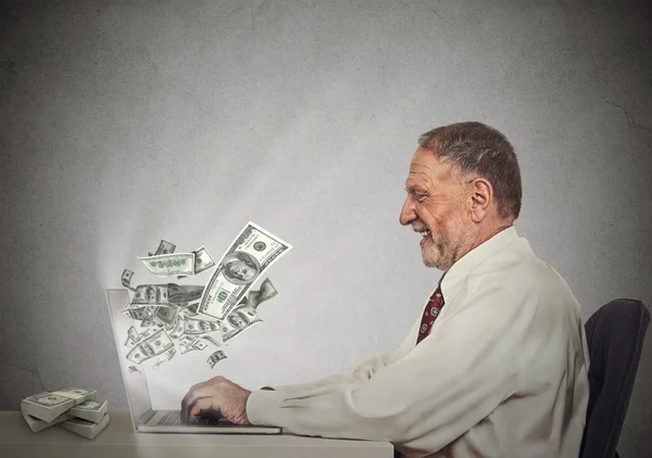 Sonriente hombre de negocios que trabaja en línea en la computadora ganando dinero — Foto de Stock